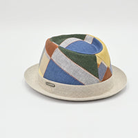 Colorful geometric-patterned pork pie hat on a light gray background
