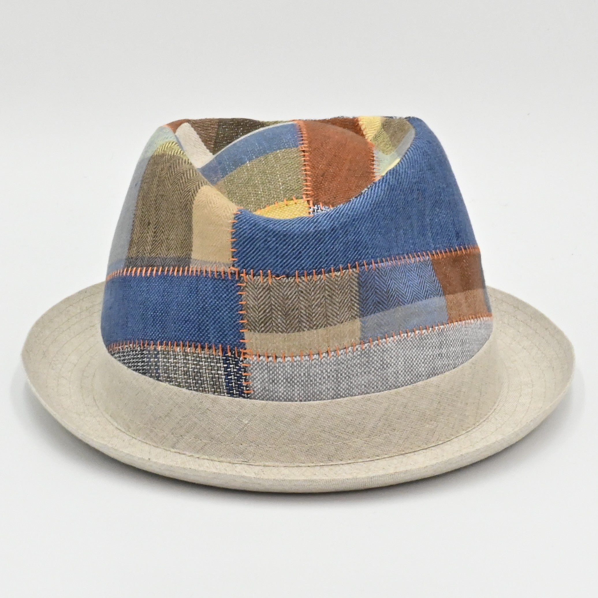Front of Italian Patchwork multicolor pork pie hat with a beige base on a light gray background