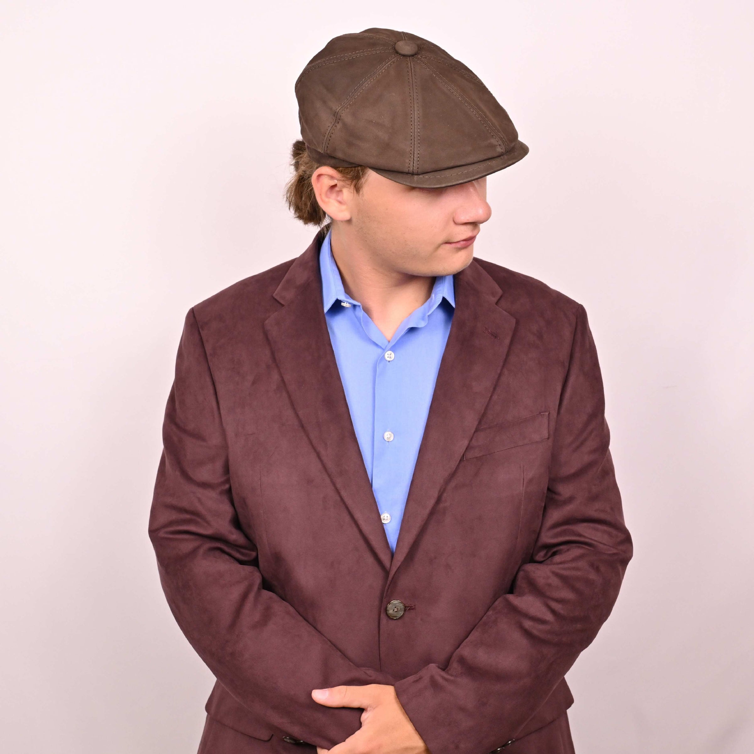 Person in brown leather newsboy hat