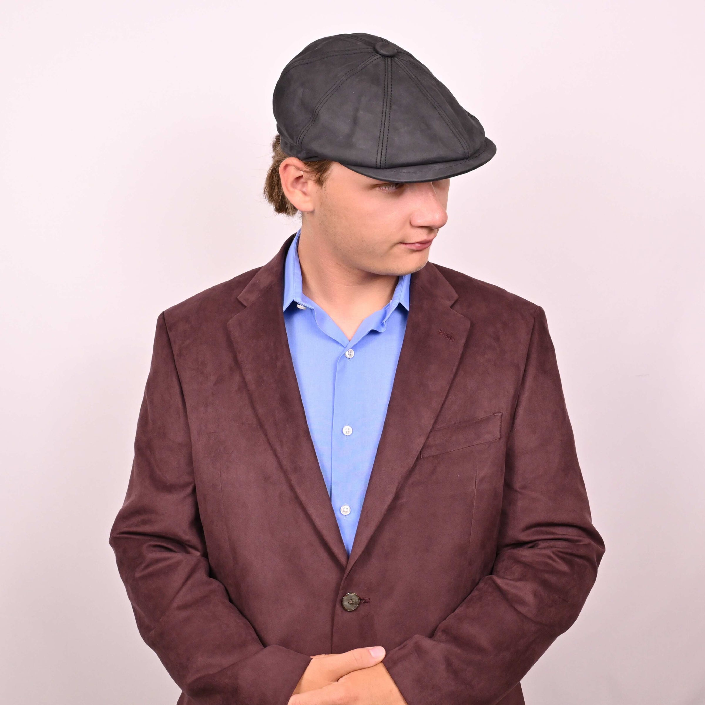 Person in black leather newsboy hat