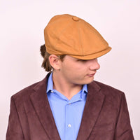 Person in cognac leather newsboy hat