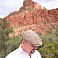 man in Multicolor Mantova Striped Newsboy Hat with red rocks in background