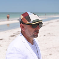 man in multicolor Burano Patchwork Linen Summer Cap on the beach