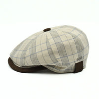 Beige Bartolomeo linen cotton newsboy hat with plaid pattern and leather visor on white background