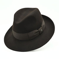 1930's style brown wool hat with metal logo on white background 
