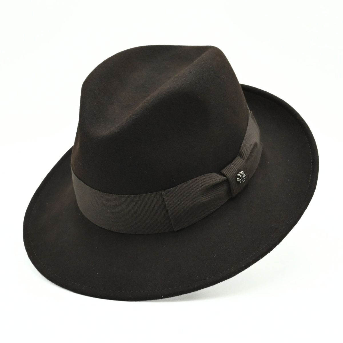 1930's style brown wool hat with metal logo on white background 