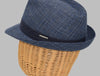 This image features a stylish Alpine fantasy hat made from a light, textured fabric with a blue band around the crown. It has a classic shape, with a slightly curved brim and a subtle logo on the side. The hat's neutral color and sophisticated design make it suitable for a variety of occasions.