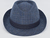 This image features a stylish Alpine fantasy hat made from a light, textured fabric with a blue band around the crown. It has a classic shape, with a slightly curved brim and a subtle logo on the side. The hat's neutral color and sophisticated design make it suitable for a variety of occasions.