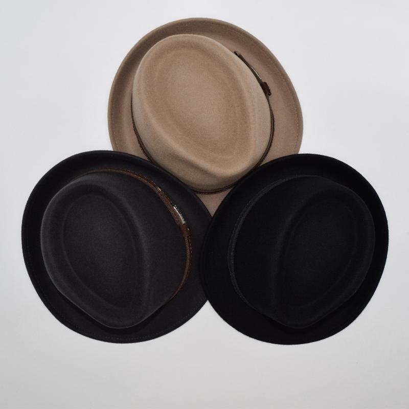 Top view of three alpine hats in beige, brown, and black, highlighting their smooth, structured crowns and classic ribbon bands for a refined aesthetic