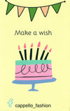 yellow back page of birthday card with pink and green cake with black candles. 