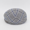 The back view of a gray flat cap with a blue and white plaid pattern, showcasing its symmetrical stitching and subtle metallic logo accent.