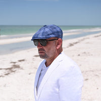Man in Blue Portofino Newsboy Hat with ocean in background