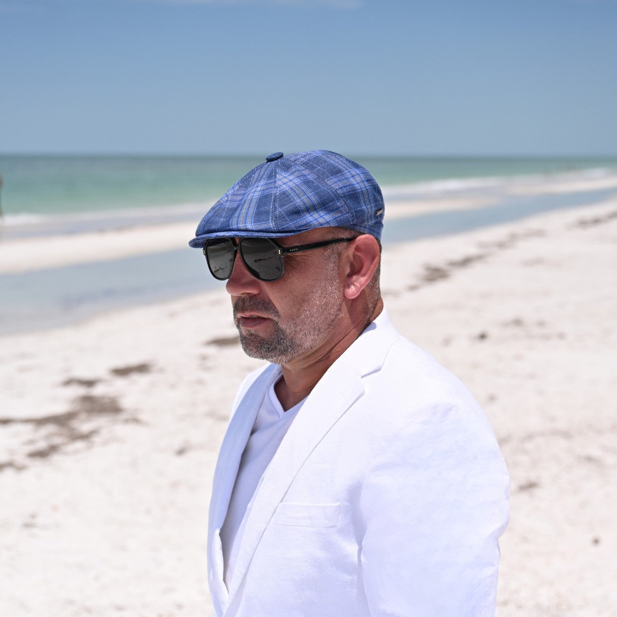 Man in Blue Portofino Newsboy Hat with ocean in background