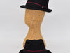 Two black alpine hats with burgundy-accented ribbon bands, one displayed on a wicker mannequin head and the other resting flat, showcasing their elegant design and structured crown