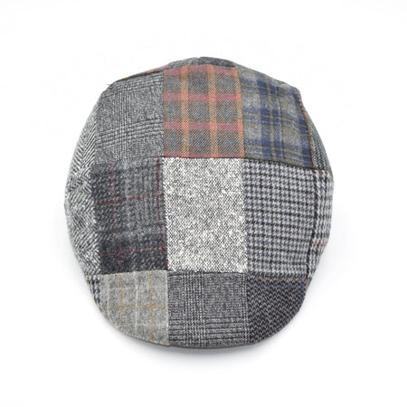 Top-down view of a grey patchwork flat cap showcasing a variety of textured plaid and checkered patterns in neutral tones with hints of red, blue, and brown accents, forming a cohesive and stylish design.