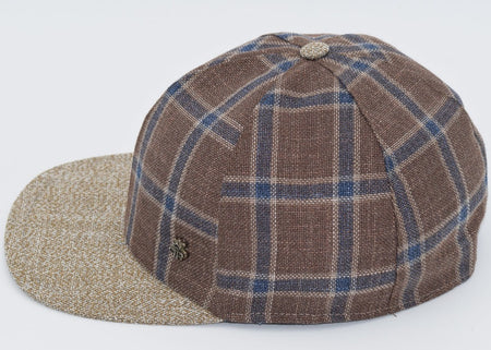 Brown plaid baseball cap with blue and beige checkered patterns, a textured beige brim, and a matching fabric button on top, featuring a small metallic logo detail on the side.