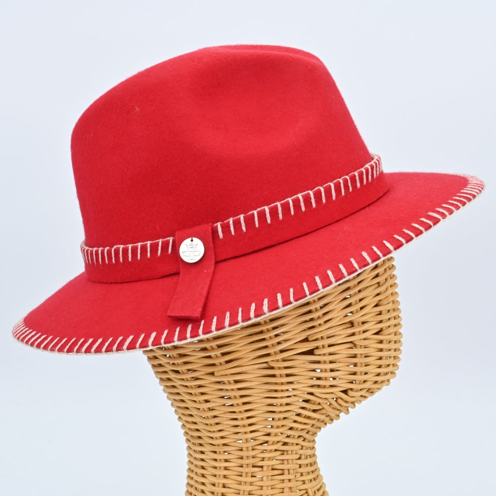 A bright red felt fedora hat with white decorative stitching along the brim and crown, featuring a red ribbon band with a small metallic button detail