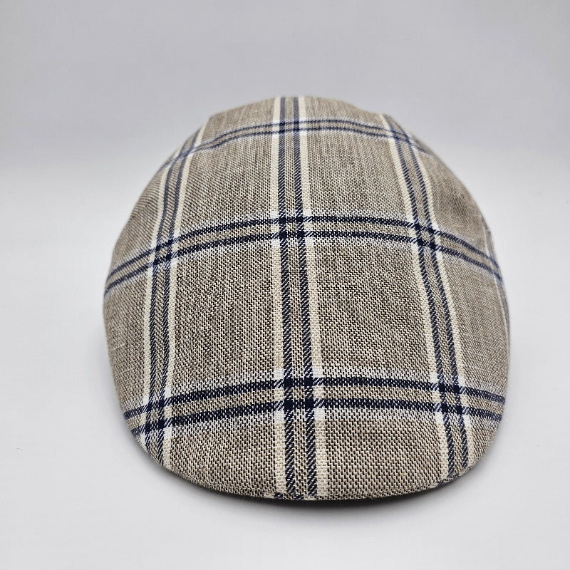 A beige flat cap with a blue plaid pattern, viewed from the front, highlighting its classic and timeless design.