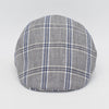 A gray flat cap with a blue and white plaid pattern, viewed from the front, highlighting its timeless and classic style.