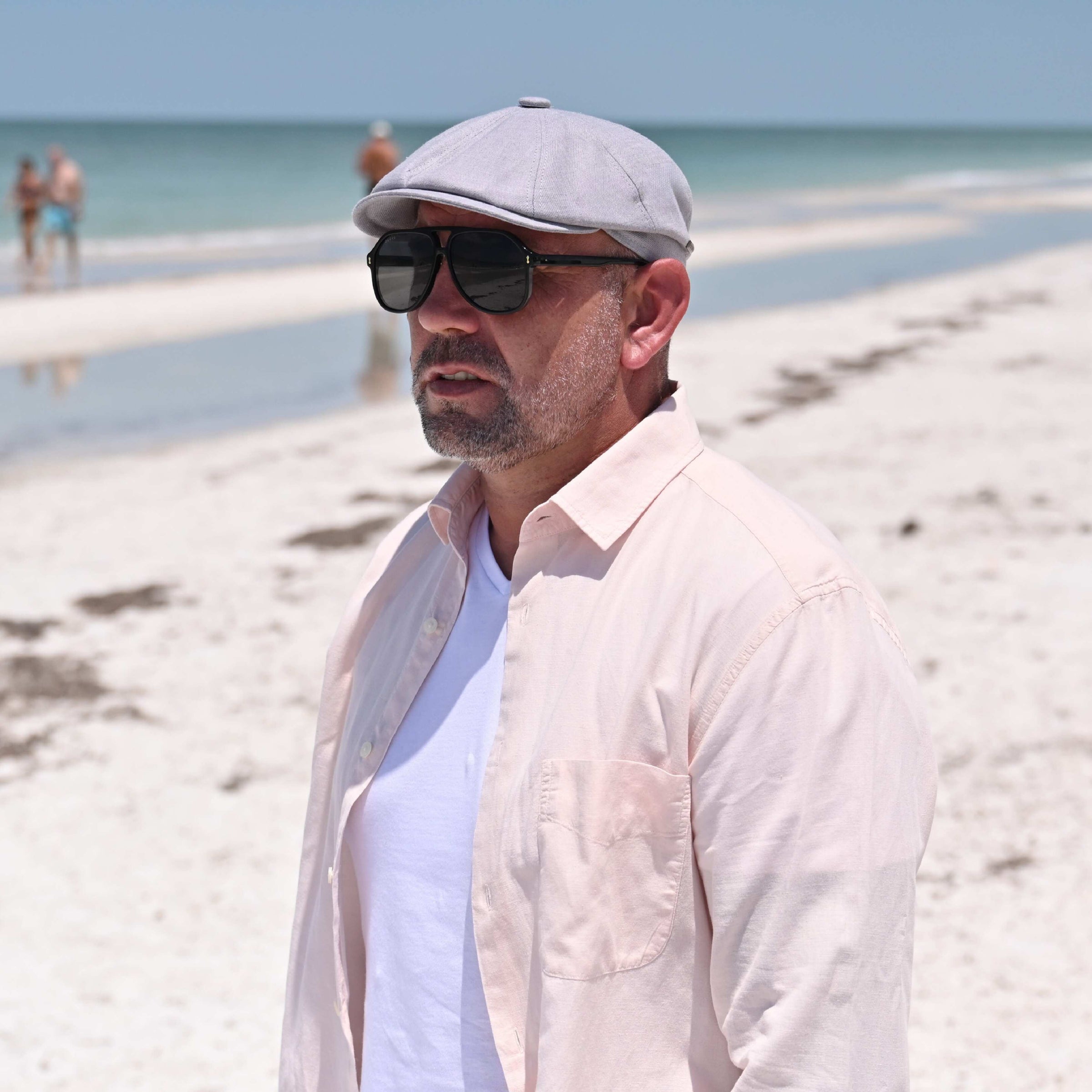 Man in Gray Grigio Linen Newsboy Hat  with ocean in background