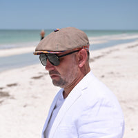 man in Multicolor Mantova Striped Newsboy Hat with beach in background
