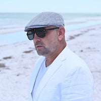 man in navy Paulo Linen Cap on the beach