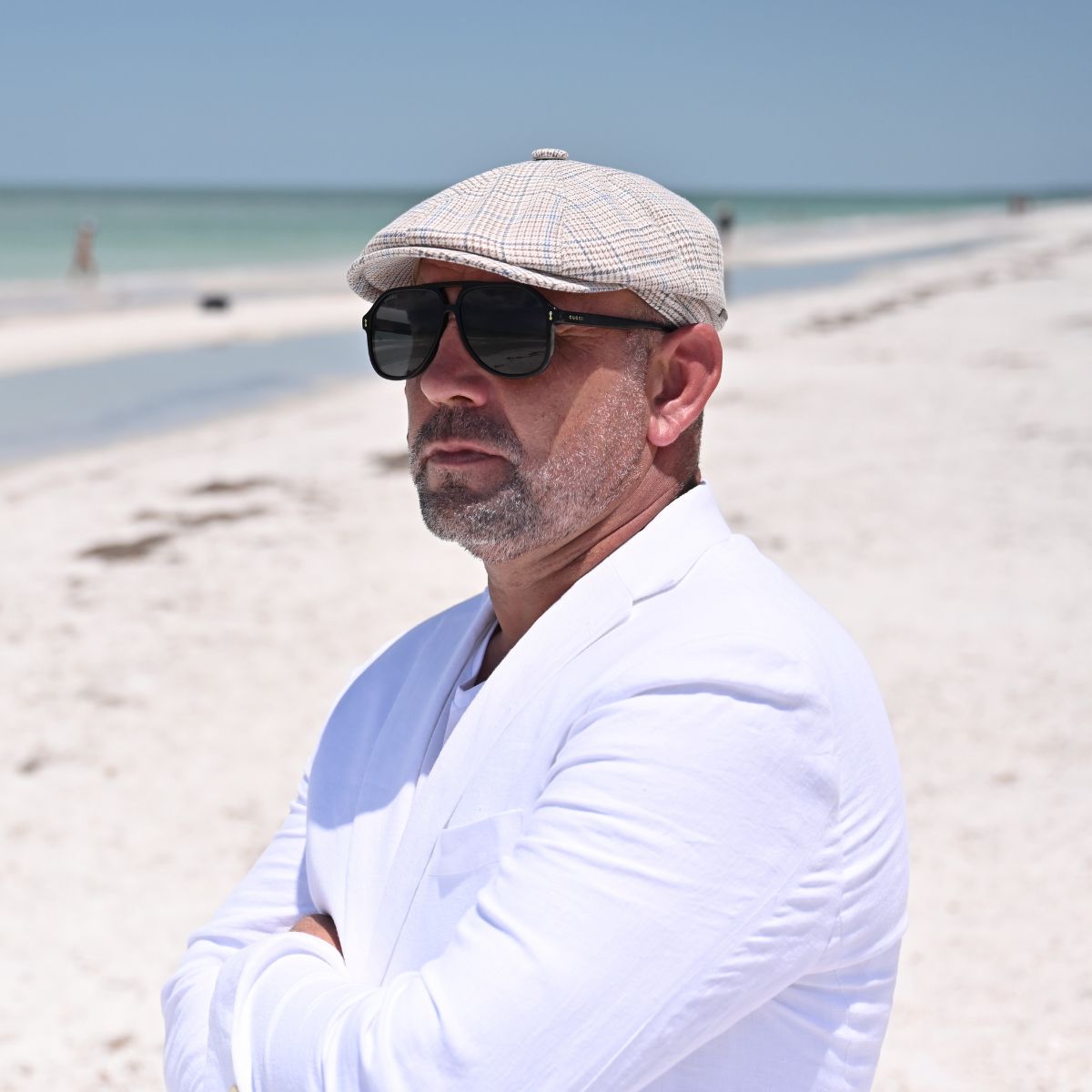 man in beige Prince of Wales Linen Newsboy Hat on the beach