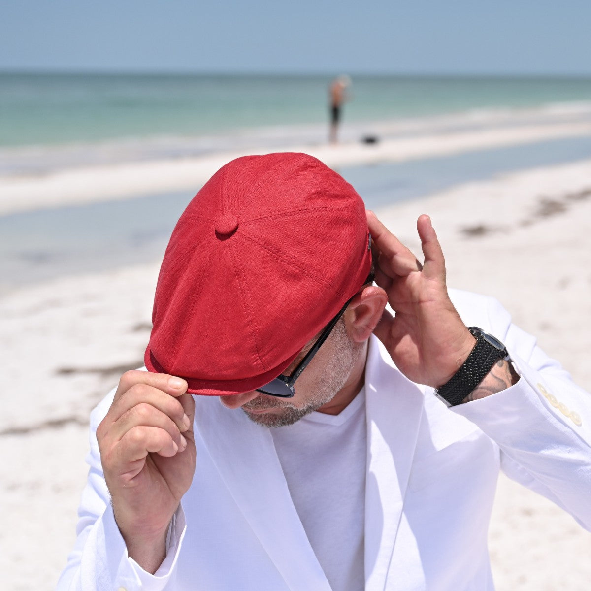 Man in Red Rosso Linen Newsboy Hat with ocean in background