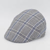 A gray flat cap with a blue and white plaid pattern, displayed at a side angle to showcase its curved design and detailed craftsmanship.