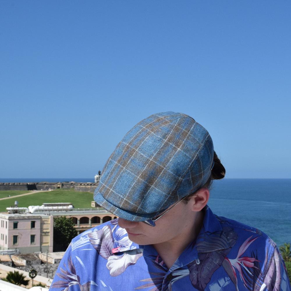 black and blue Silk Cup on the model in blue floral shirt with ocean and buildings in background