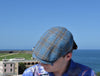 black and blue Silk Cup on the model in blue floral shirt with ocean and buildings in background