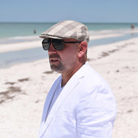 man in beige Trieste Plaid Driver Cap on the beach