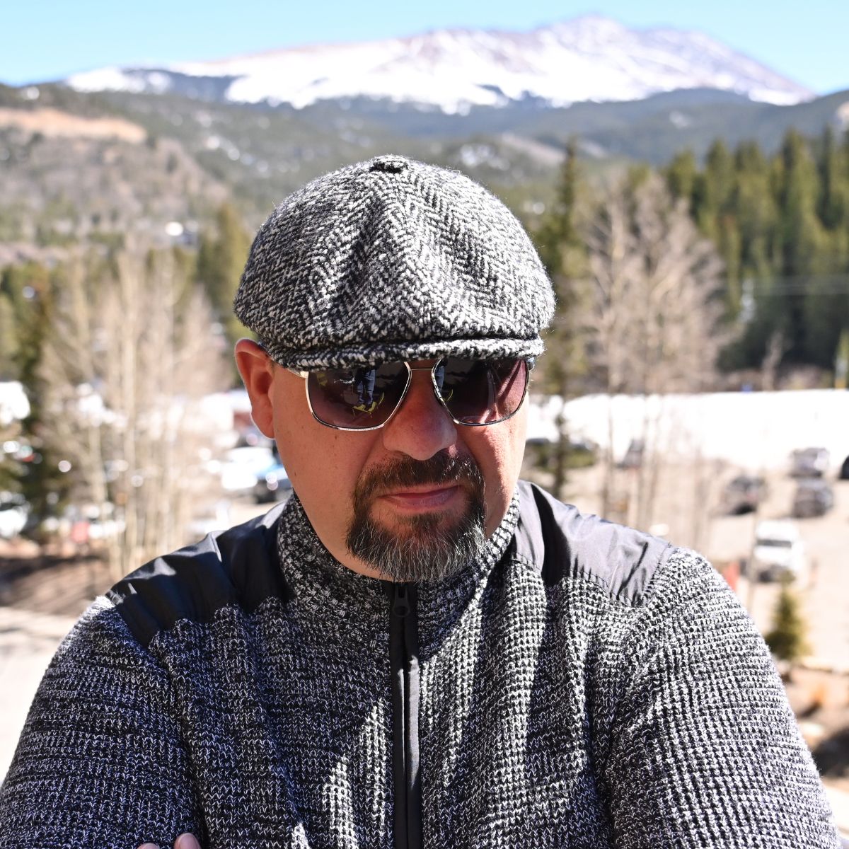 Grey Herringbone Pattern Newsboy Hat front view on the model with mountains in background