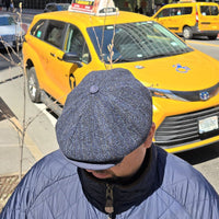 Guy in Navy Liguria Peaky Style Italian Hat with yellow cab in background