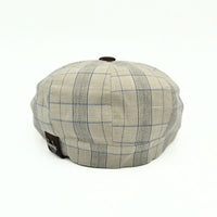 Beige Bartolomeo linen cotton newsboy hat with plaid pattern and leather visor on white background