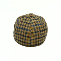Bolzano Heritage Wool Baseball Cap featuring a brown and navy blue plaid pattern on the crown, with a textured brown visor and a small metal brand tag on the side, set against a plain white background.