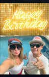 Front page of birthday card with male and female in colorful hats and white t-shirts with blue pool in background