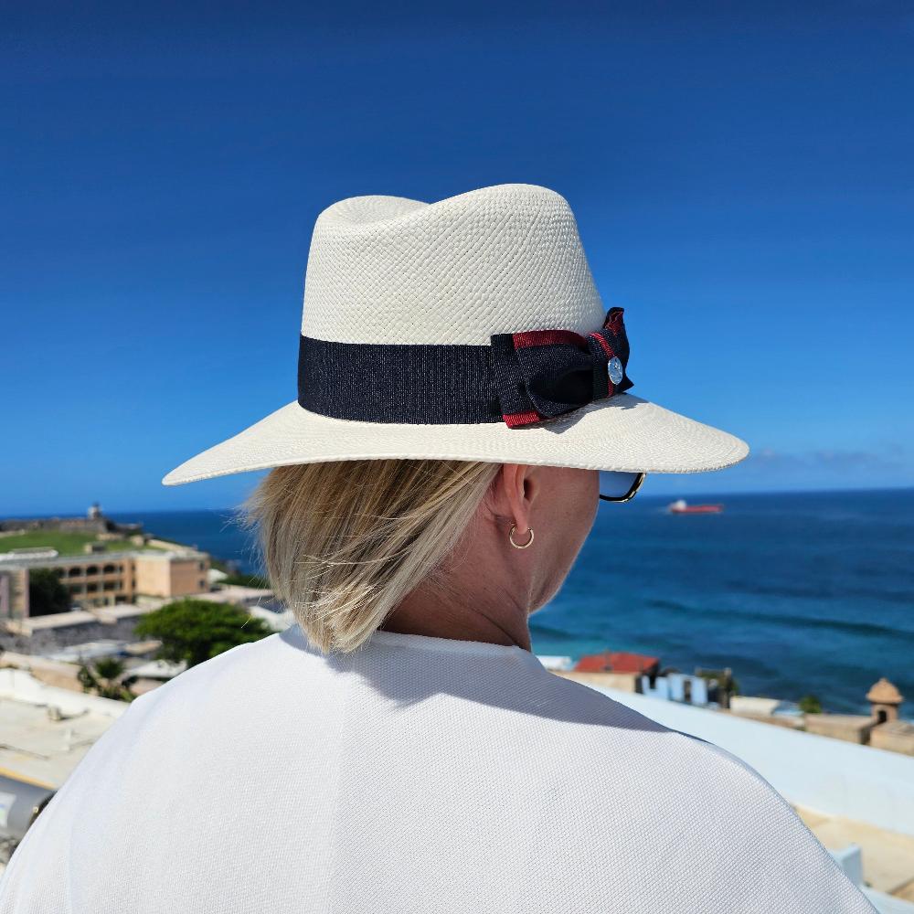 Elevate your style with this classic White Fedora Hat, perfect for any season. Handcrafted with premium materials, this hat offers a timeless silhouette and superior comfort. The navy blue and red grosgrain ribbon with a chic bow detail adds a refined touch, making it versatile for both casual and formal occasions.